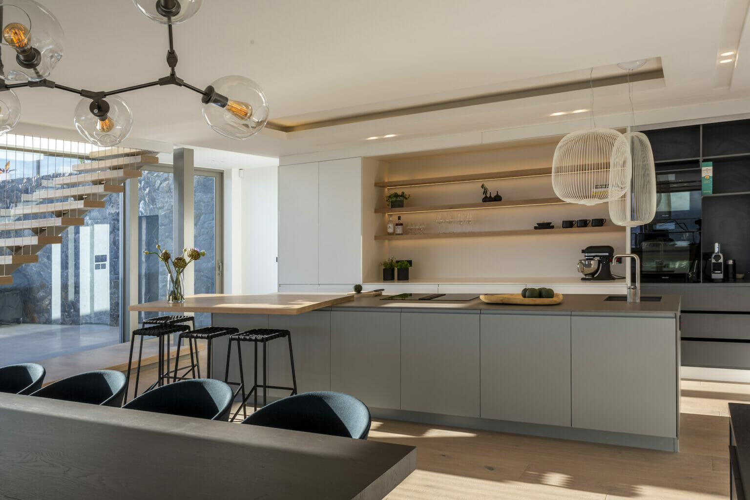 Neutral and minimalist kitchen design with timber shelving and cantilevered breakfast bar